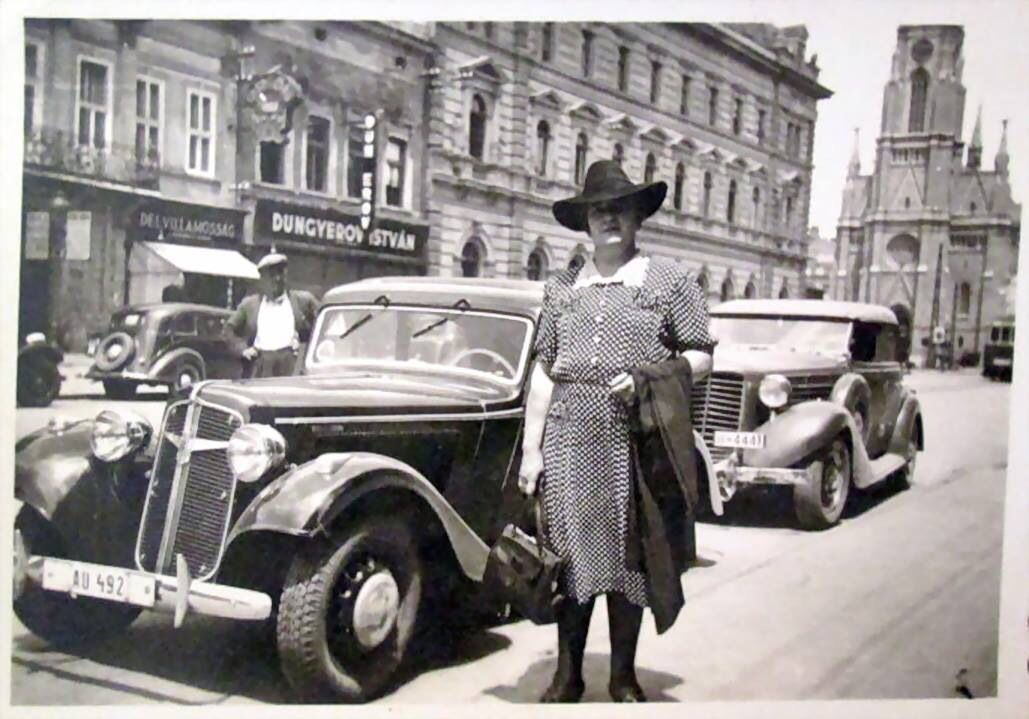 A woman beside a parked car, Liberty Square, Novi Sad, 1942
